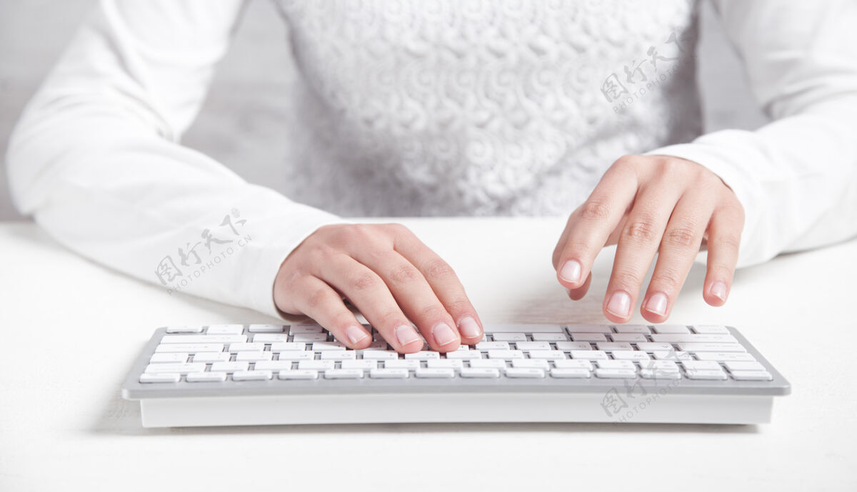 桌子在办公桌上用电脑键盘打字的女孩忙碌通信房子