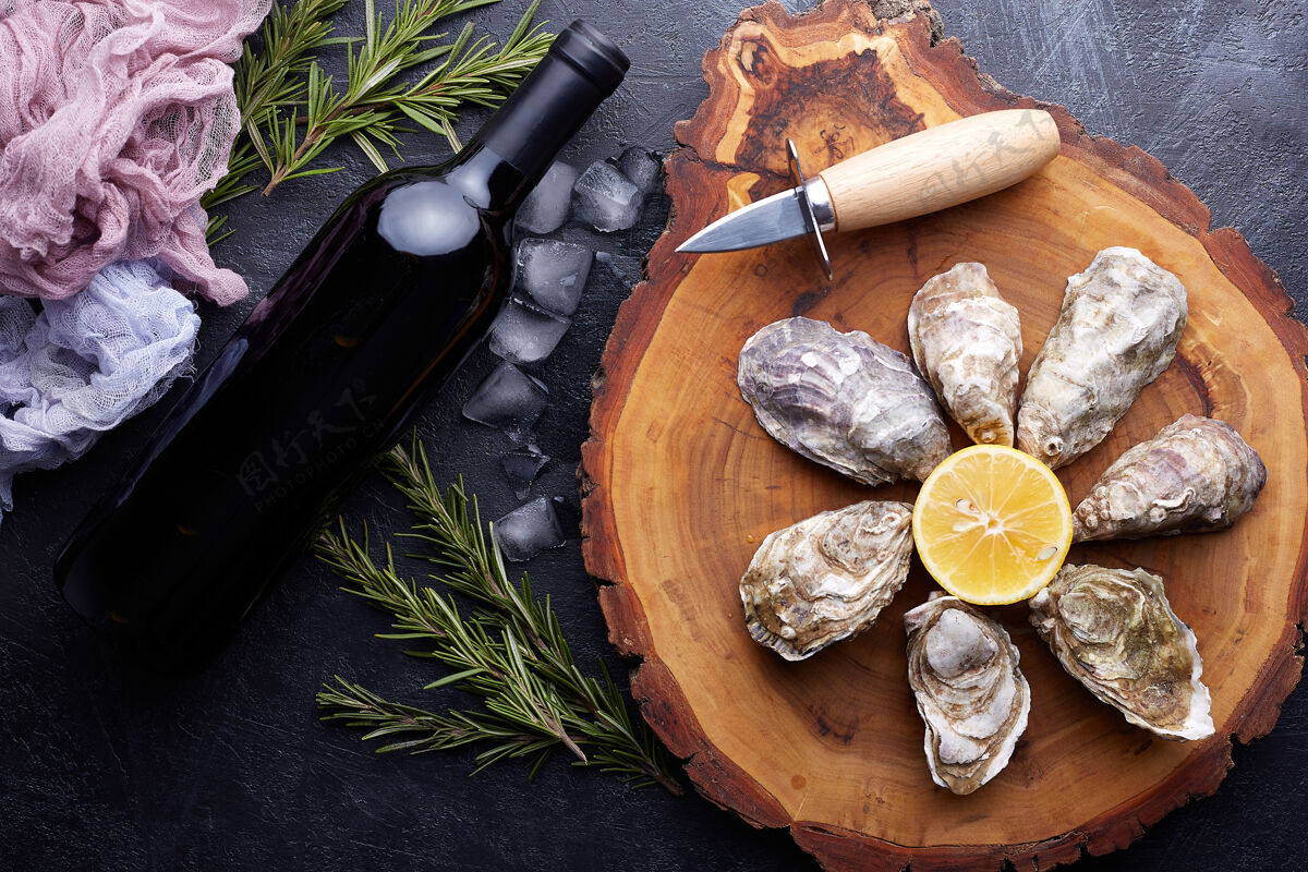 金属新鲜的封闭牡蛎 冰和柠檬放在一个圆形盘子里 石头质地的切割餐桌大理石