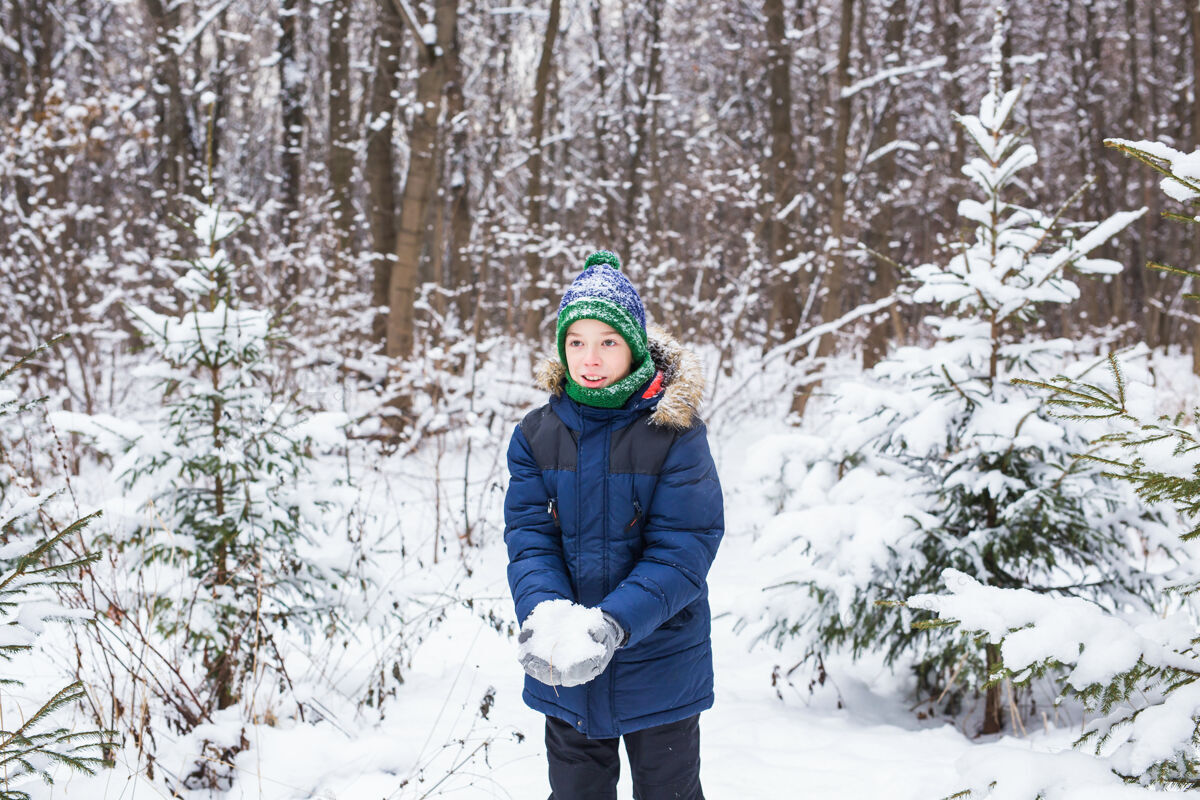 玩耍快乐男孩投掷斯诺孩子季节和冬季概念家庭下雪男孩