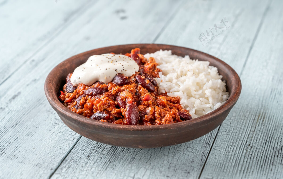 传统一碗米饭和酸奶油的辣椒肉酱香料部分午餐