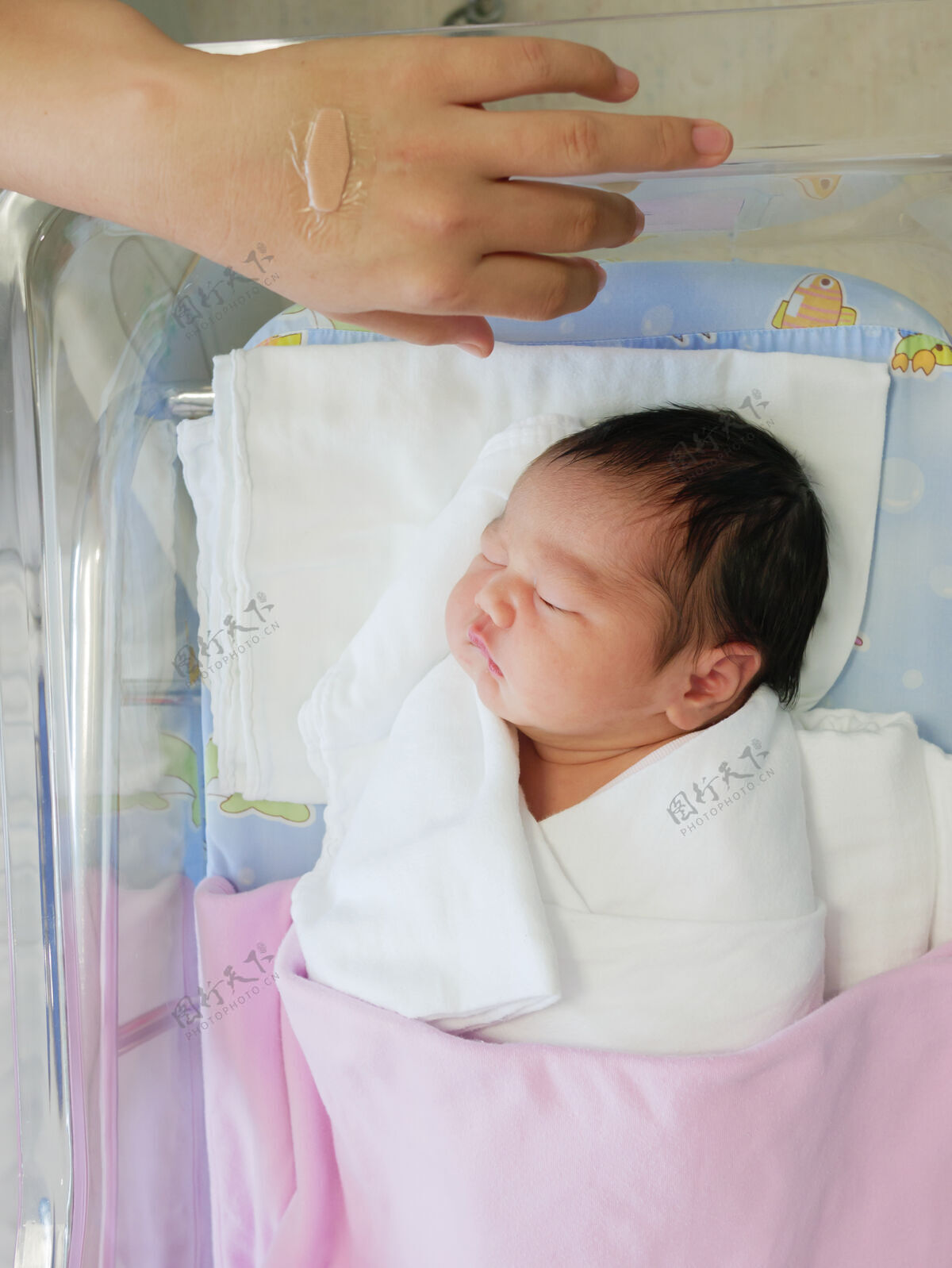 可爱睡在医院病床上的亚洲新生儿孩子新的年轻