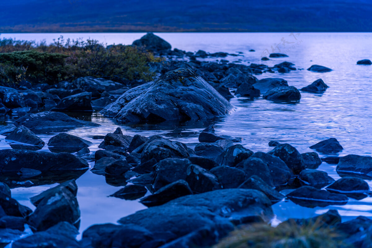 夜晚水中有岩石的夜景蓝色小时石头特写