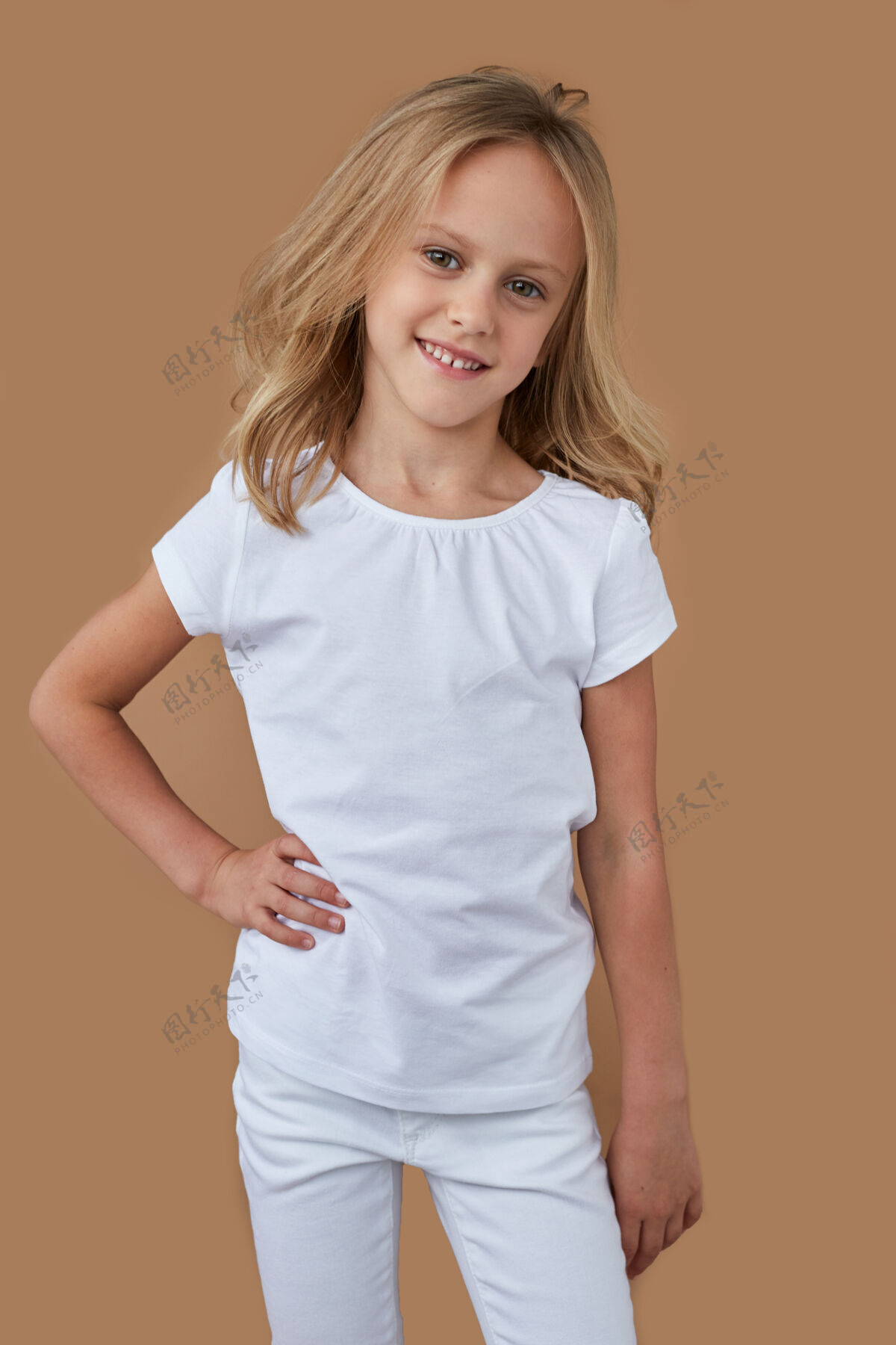 白布正面肖像是可爱的金发小女孩 卷发 穿着白色衣服 微笑着姿势童年孩子