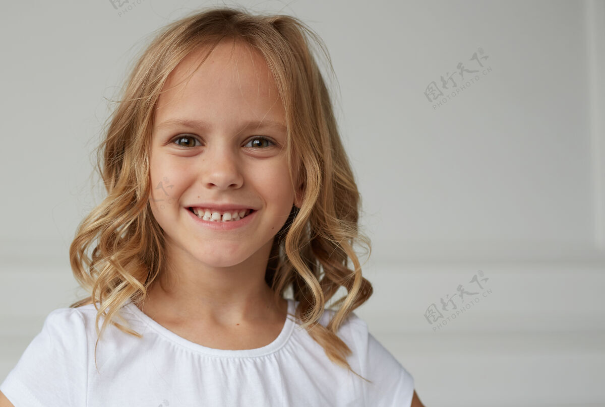 时尚特写镜头前一个小女孩微笑着看着镜头 穿着白衬衫 勇敢而漂亮的女孩工作室年轻金发