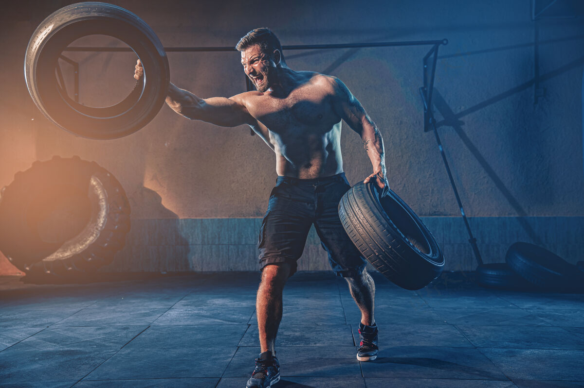 实践健美训练 大胡子强壮的运动员 肌肉发达的身体举起沉重的轮子在健身房力量翻转身材
