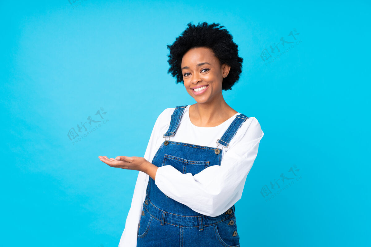 非洲一位非洲裔美籍女子 戴着蓝色的项圈 向侧面伸出双手 欢迎前来成人女人酷
