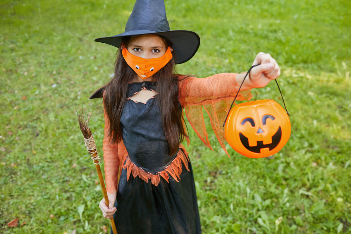 蜘蛛穿着女巫服装的小女孩站在户外 抱着篮子 请求款待的画像季节神秘孩子