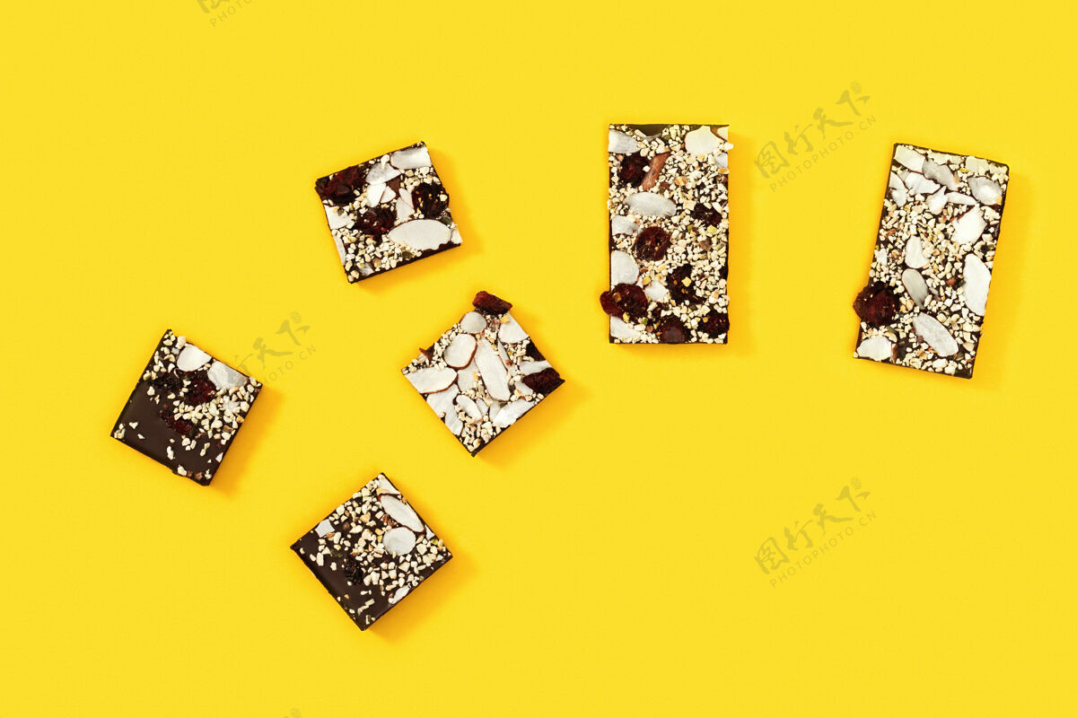 纸张被咬的巧克力条被分成几块 巧克力加坚果和干果粉碎糖果多