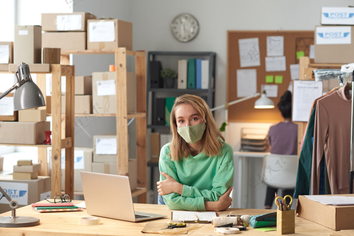 工艺戴着防护面具的年轻女商人在办公室工作时注视前方的画像计算机流行病现代