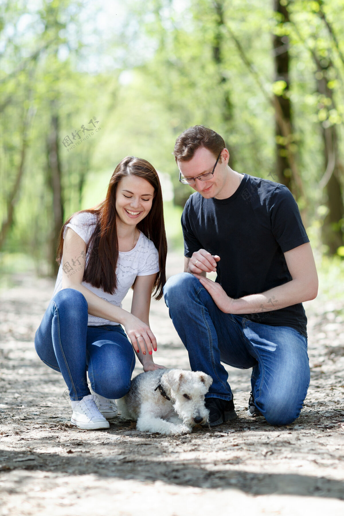 家庭快乐的年轻夫妇和狗在公园浪漫英俊美丽