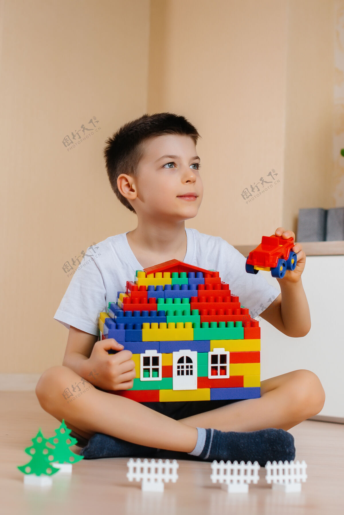 活动一个小男孩玩着一个建筑工具 为全家建造了一座大房子建造一个家庭住宅特写保护游戏