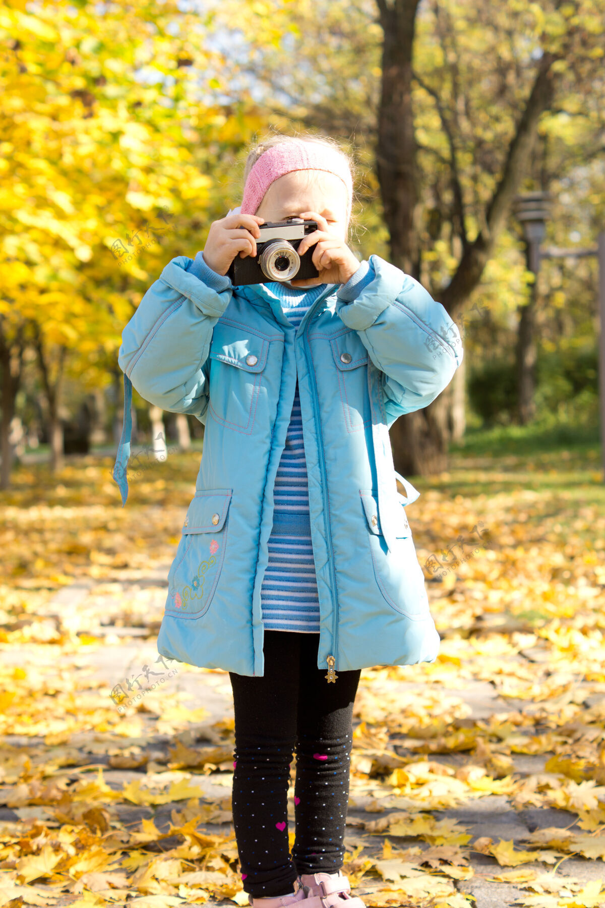 摄影师小女孩玩着老式相机在五彩缤纷的秋天公园里拍照自然森林复古