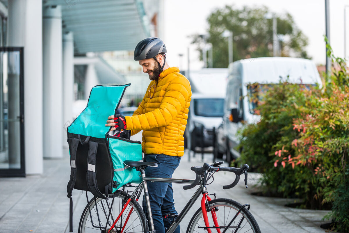电子商务送菜服务 骑手用自行车送菜给客户-关于交通 送菜和技术的概念城市食物外卖