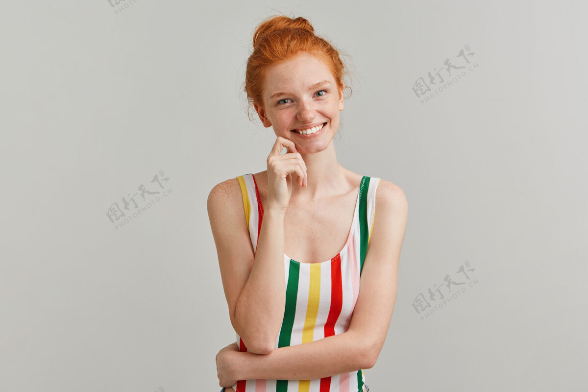 脸一幅迷人 开朗的女孩的画像 带着姜黄色的发髻和雀斑 穿着条纹的彩色泳衣红发紧身人