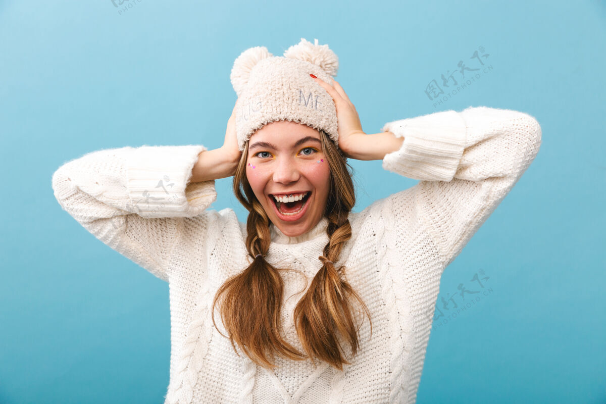 成人可爱的小女孩穿着冬装孤零零地站着 笑着时髦人花哨