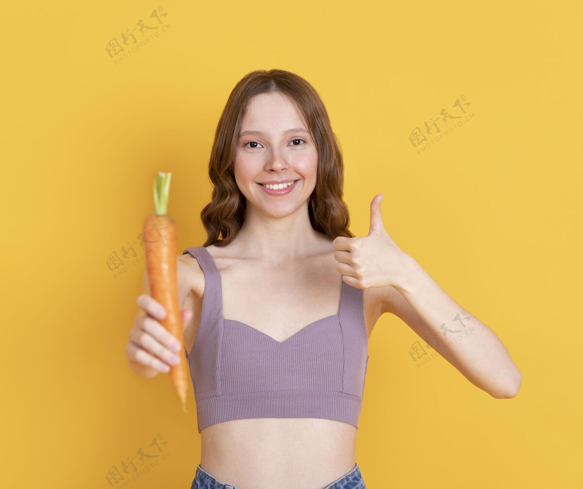 模特拿着胡萝卜的中枪女人生活方式食品营养