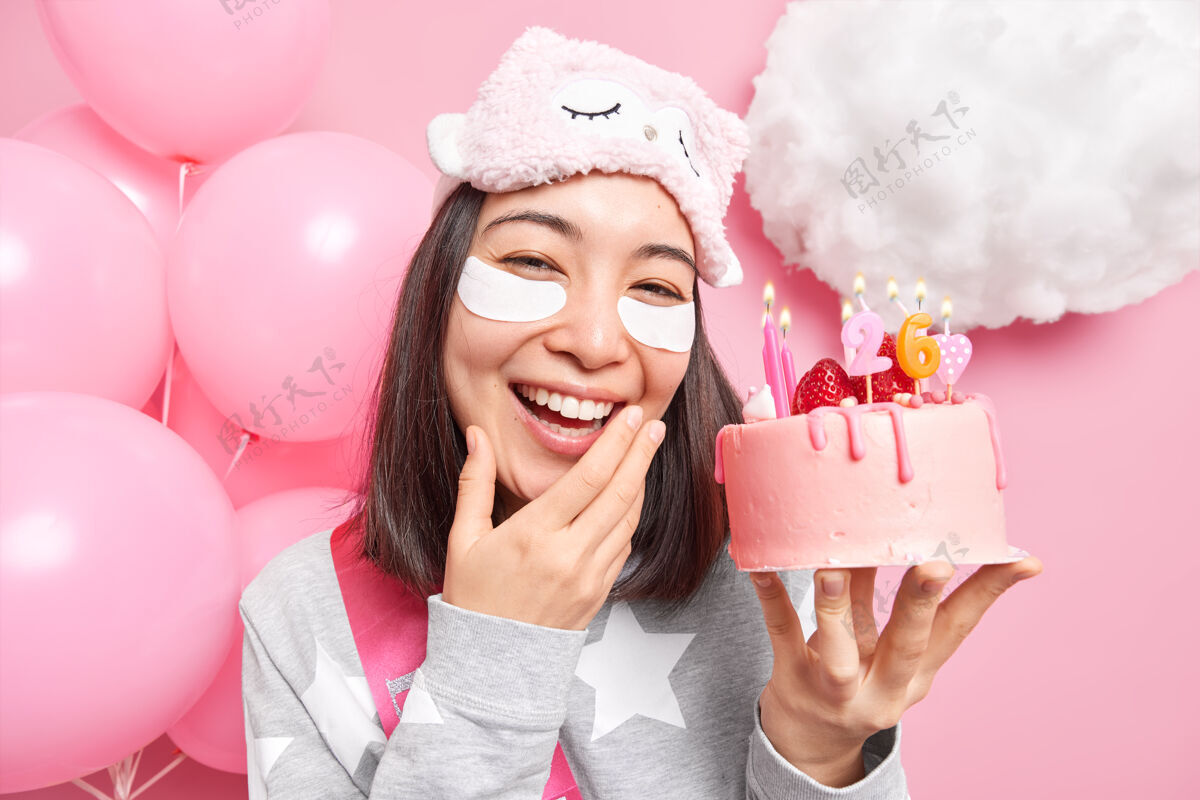 亚洲女孩微笑着宽大地拿着节日蛋糕享受庆祝26日的快乐在家里接受美容治疗在派对前穿上睡衣房子蒙眼甜点