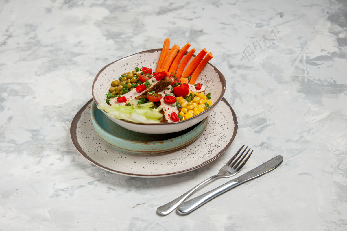 各种美味沙拉的正面图 各种配料放在托盘上的盘子上 餐具放在白色表面 有自由空间盘子饮食配料