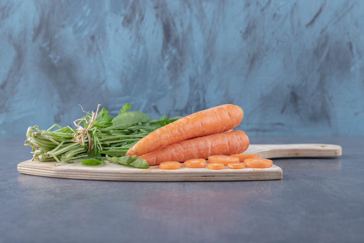 美味把豆瓣菜和胡萝卜放在砧板上 放在大理石表面上板生的美味