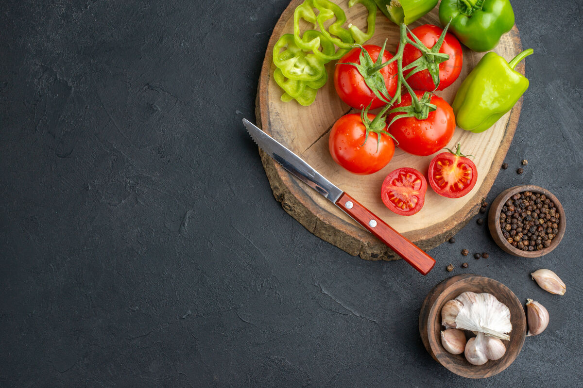 剁碎上图：切好的青椒和新鲜的西红柿刀放在木质的切菜板上 辣椒大蒜素放在左边的黑色表面上切青椒番茄