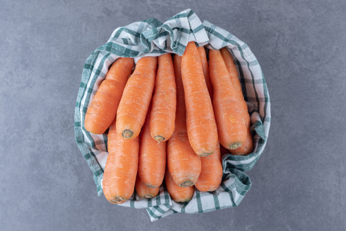 美味新鲜的胡萝卜放在碗里的毛巾上 放在大理石表面上胡萝卜茶毛巾新鲜