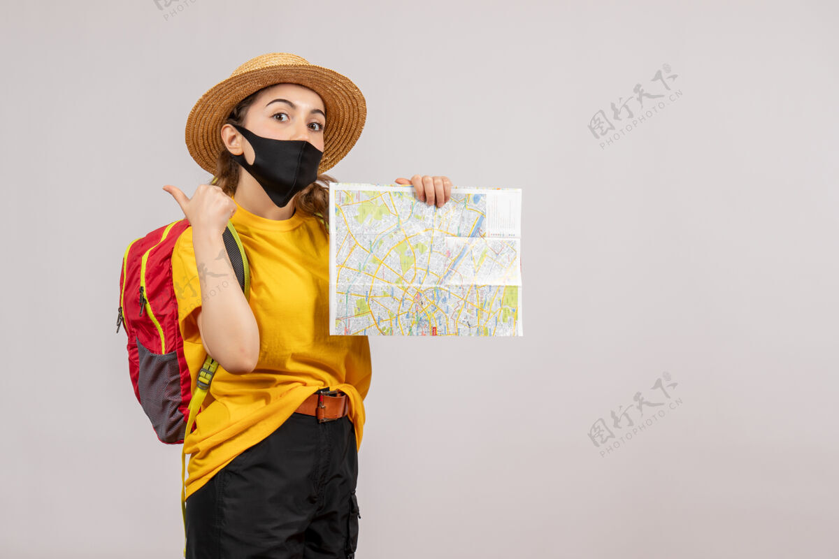 肖像正面图红色背包的年轻旅行者举着地图竖起大拇指面具旅游面罩