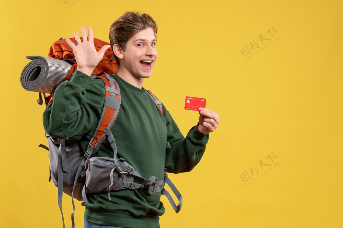 成人正面图年轻男子手持红色银行卡准备远足自然旅游旅行者