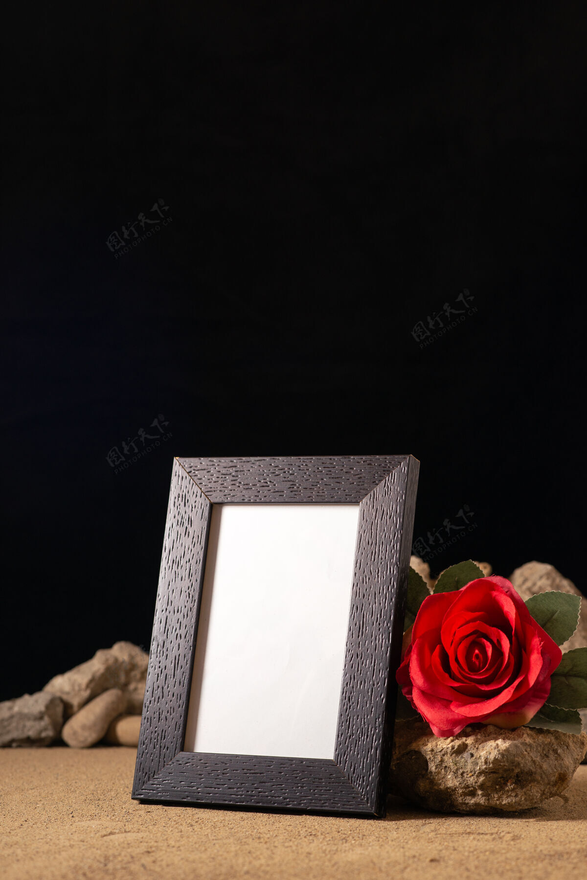 葬礼带红色花朵和黑色石头的空相框的正面视图石头玫瑰死亡