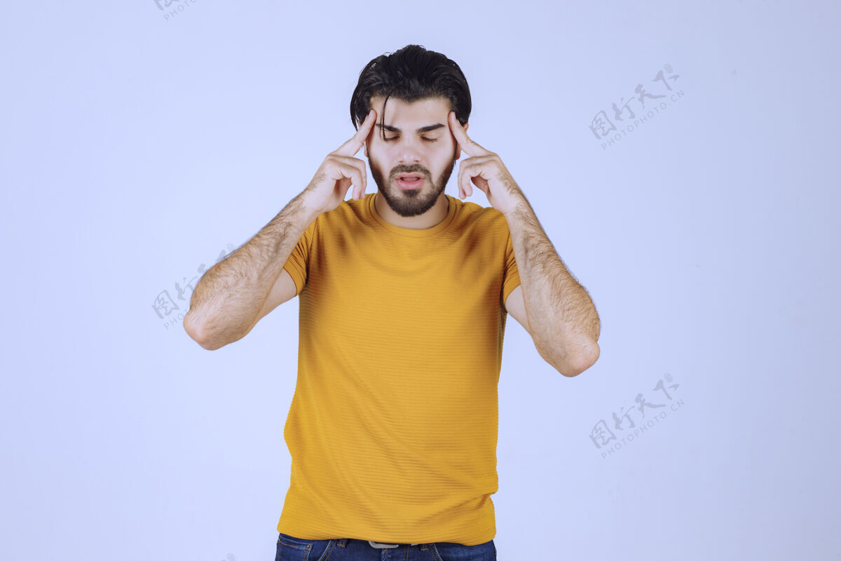 分析穿黄衬衫的人看起来很怀疑 在思考头脑风暴提升姿势
