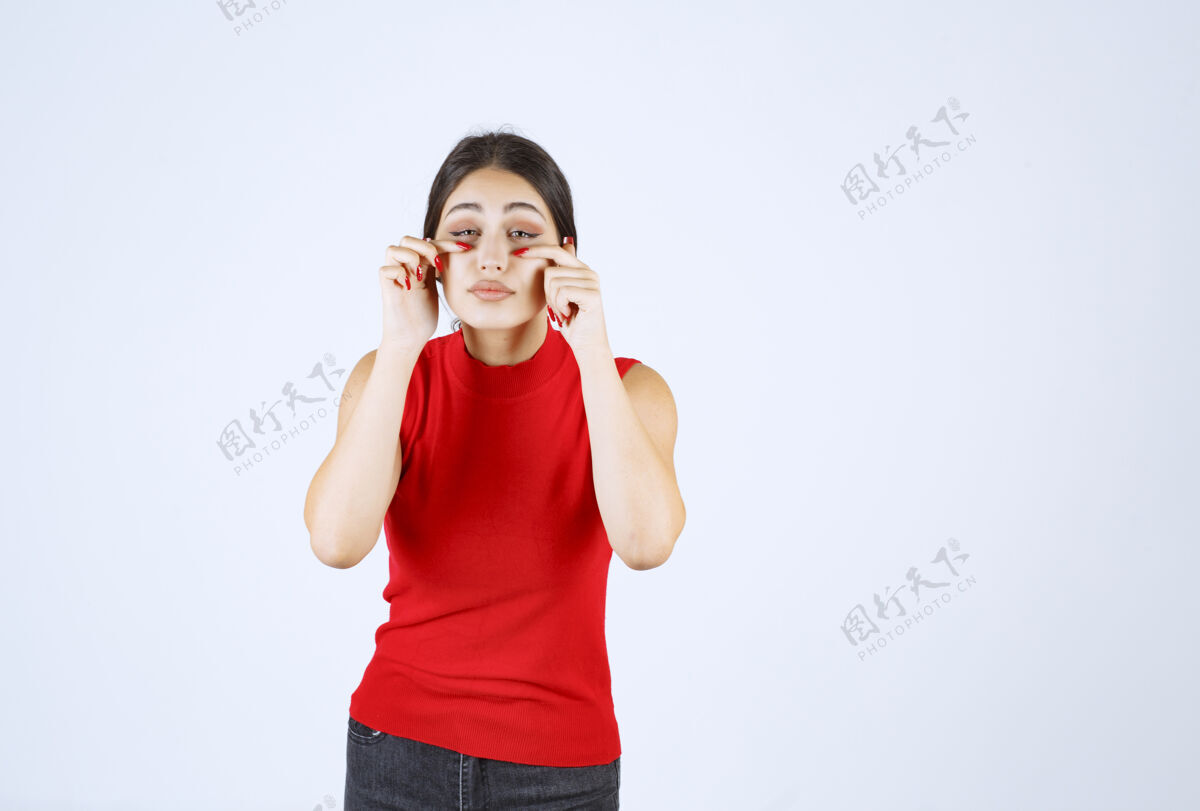 雇员穿红衬衫的女孩透过手指看女人害羞隐私