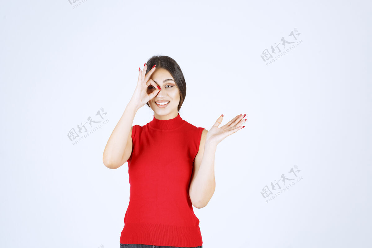隐藏穿红衬衫的女孩透过手指看职员雇员年轻人