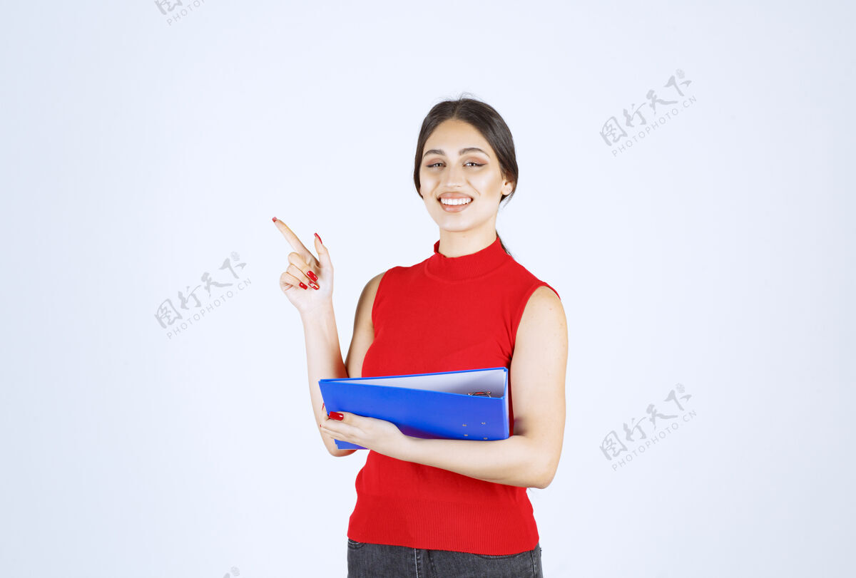 服装穿着红衬衫的女孩手里拿着一个蓝色的商业文件夹人职员检查表