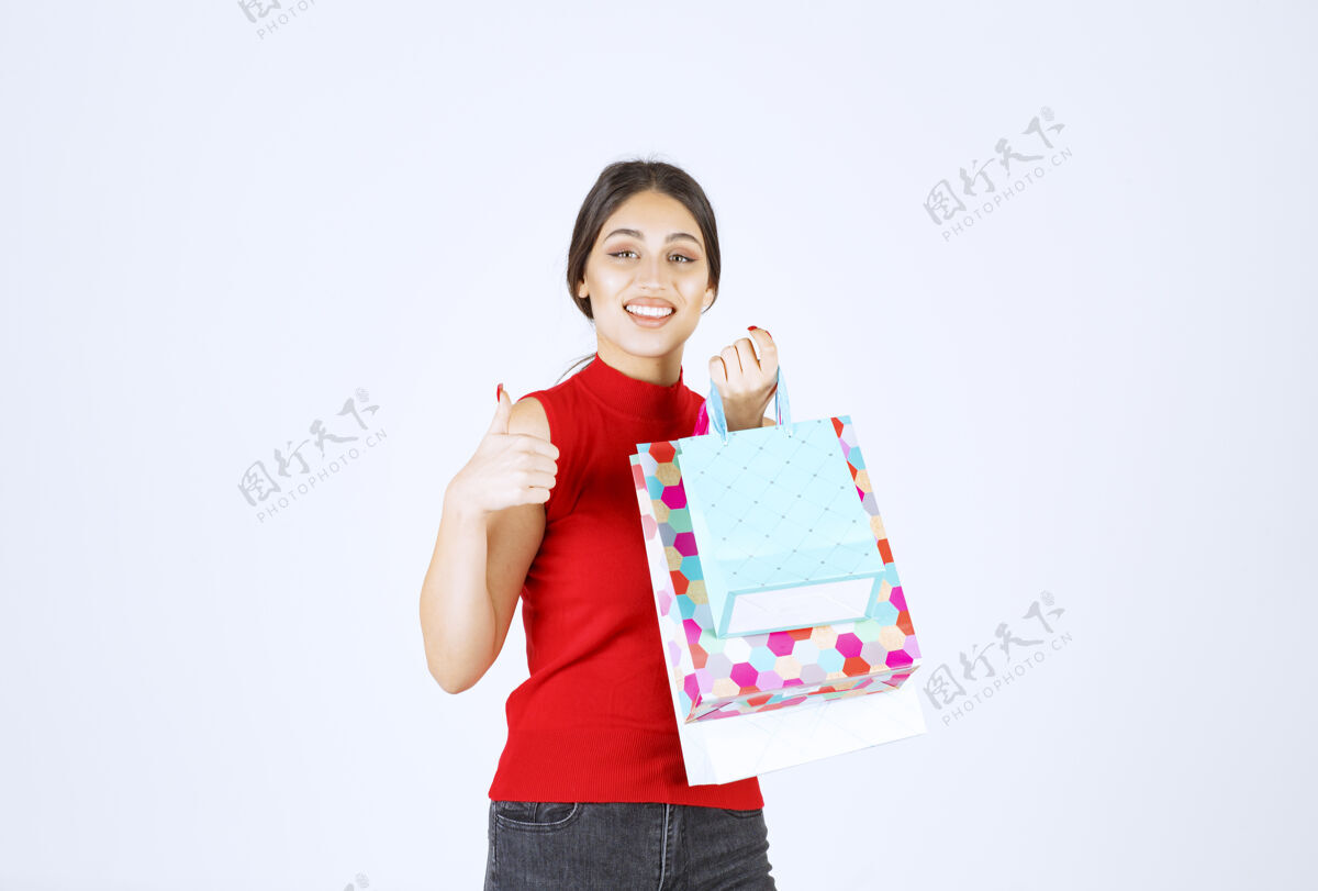 人带着五颜六色购物袋的女孩感觉很积极服装工人女人