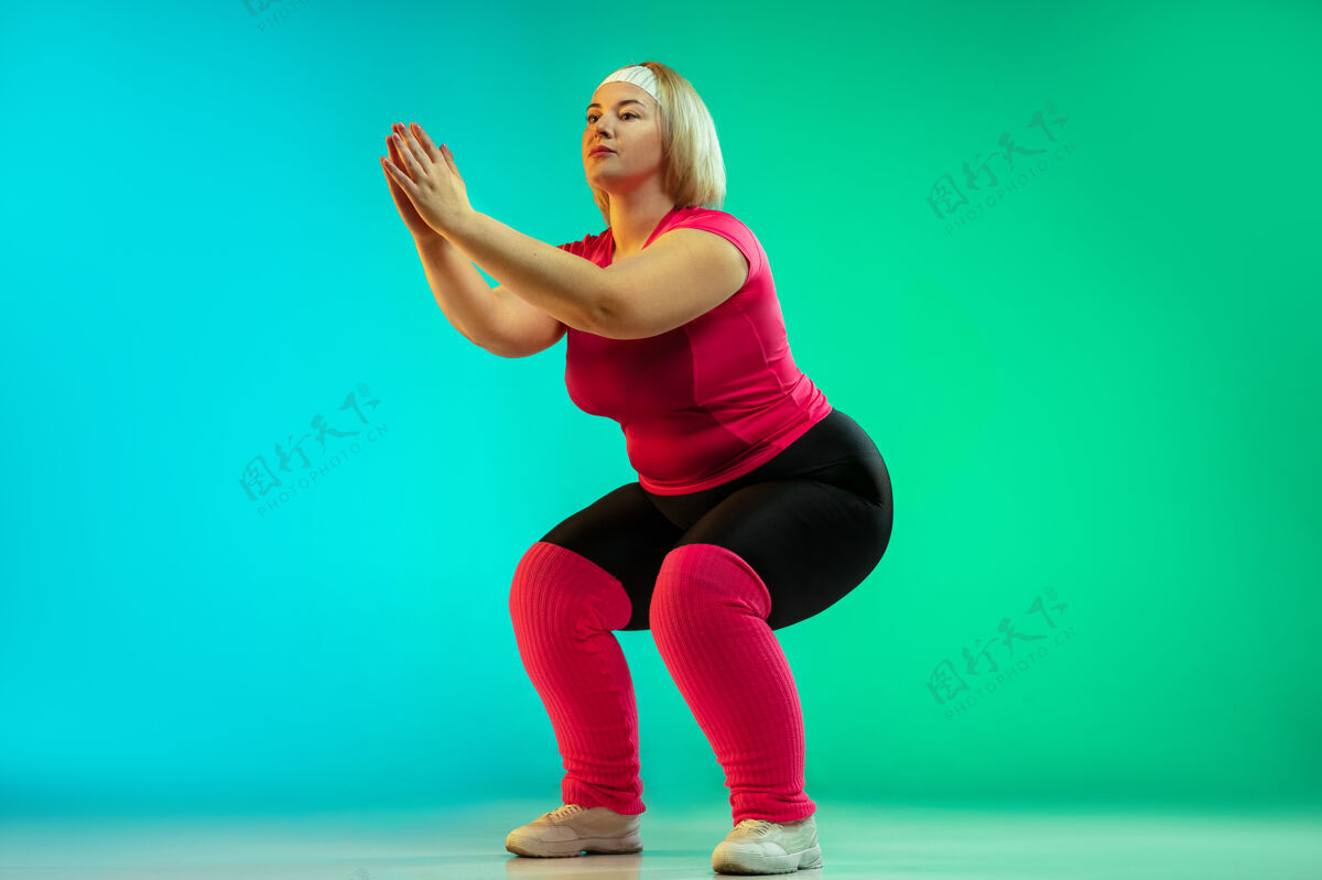 健康年轻的白人大号女模特在霓虹灯下的渐变绿色背景下进行训练锻炼 拉伸 有氧运动运动理念 健康的生活方式 积极的身体 平等健身积极肖像