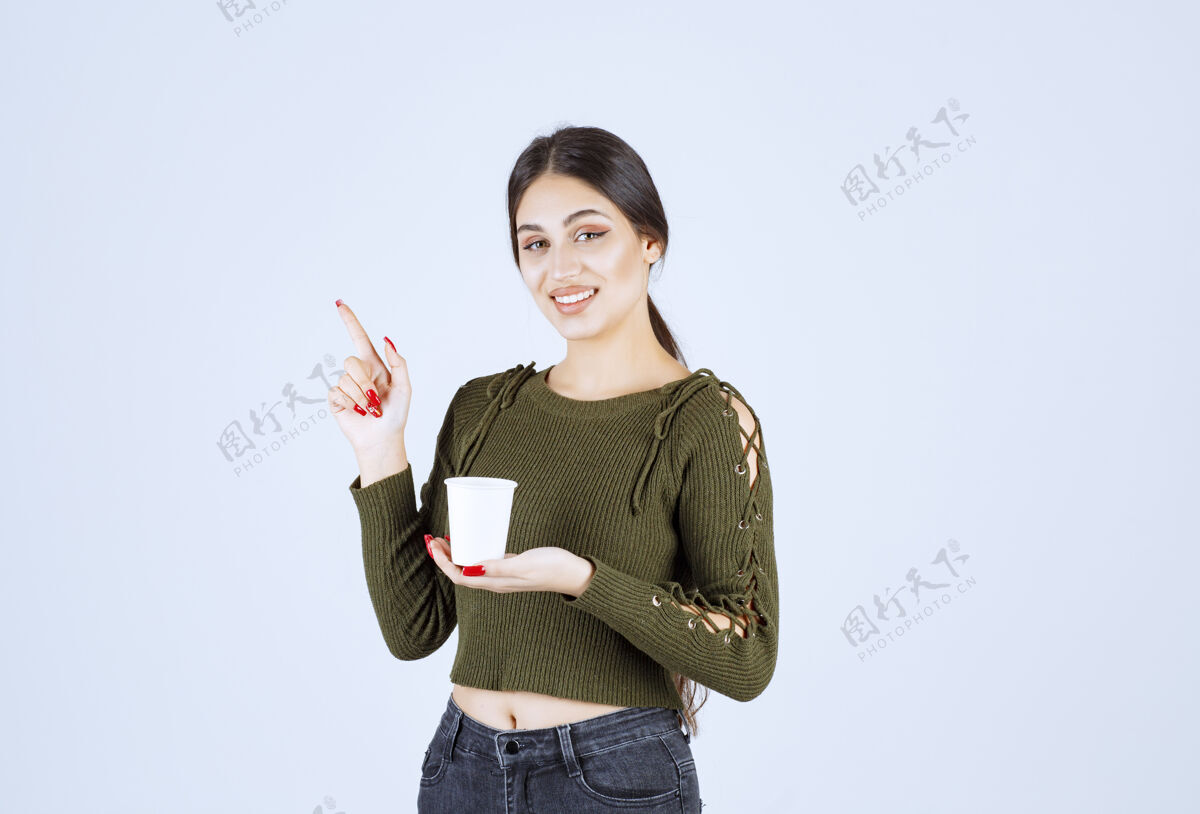 女人黑发女人拿着塑料杯指着某处女孩休闲肖像
