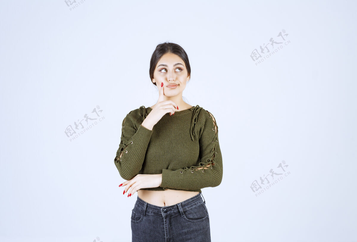肖像一位年轻漂亮的女模特站在白墙上摆姿势的画像站女孩姿势