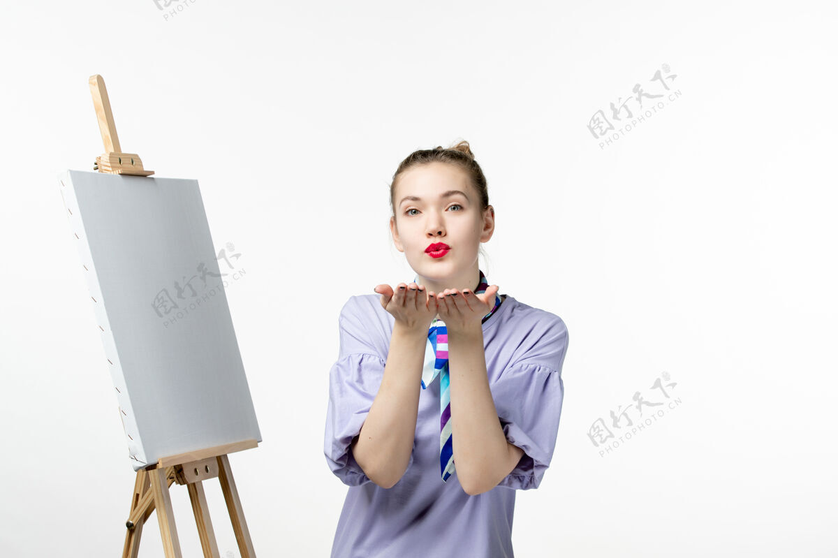 男孩正面图女画家用画架在白墙上作画摄影艺术家展览绘画艺术情感前面孩子欢呼