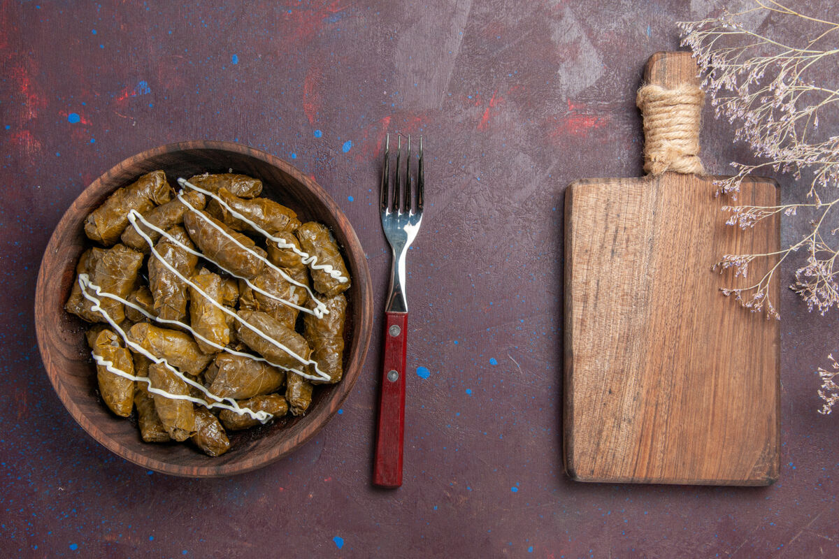 桌子俯瞰美味的多尔玛东方肉菜与树叶和肉末在黑暗的桌子上食物卡路里晚餐油菜肉厨房用具插头抹刀
