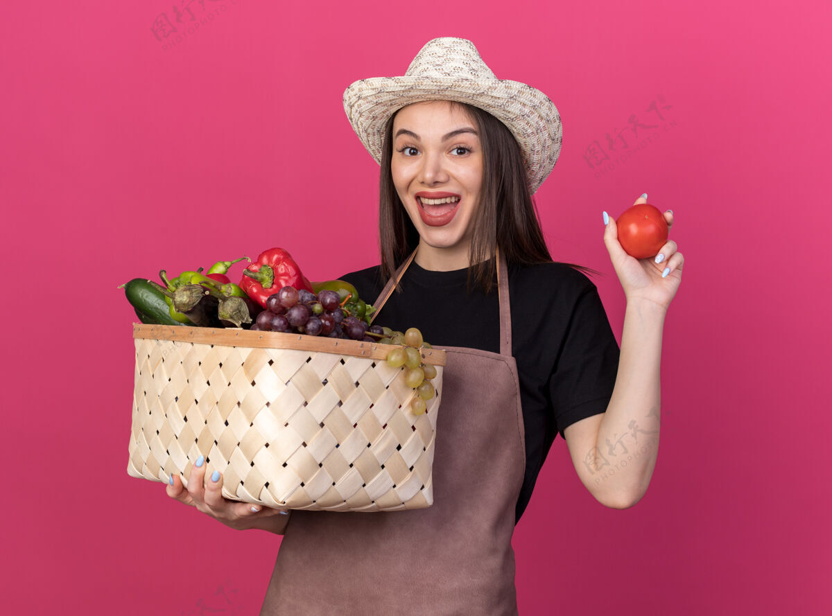 欢乐快乐美丽的白人女园丁戴着园艺帽拿着菜篮子和西红柿帽子篮子园艺