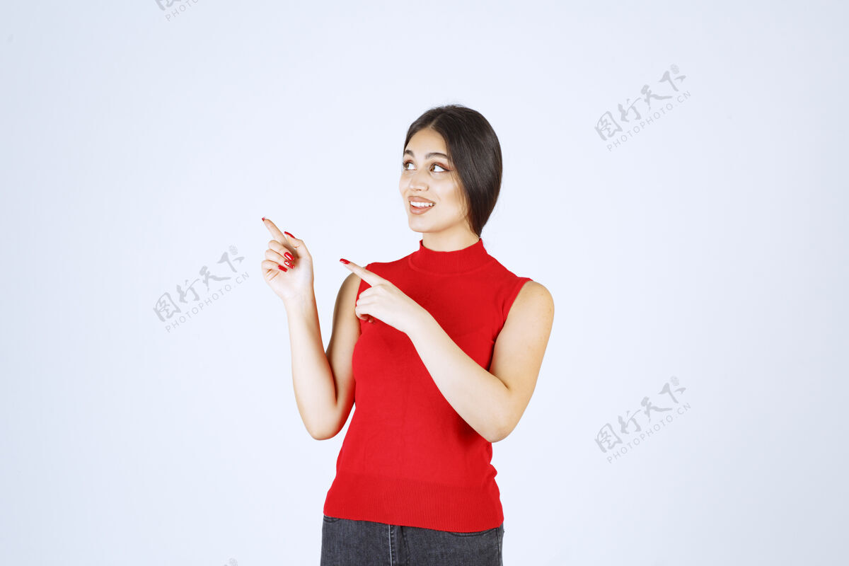 年轻人穿红衬衫的女孩在展示左边的东西女人人地点