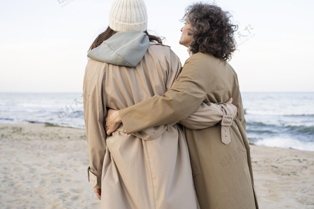 女人母女俩在沙滩上散步的背影在一起女人女儿