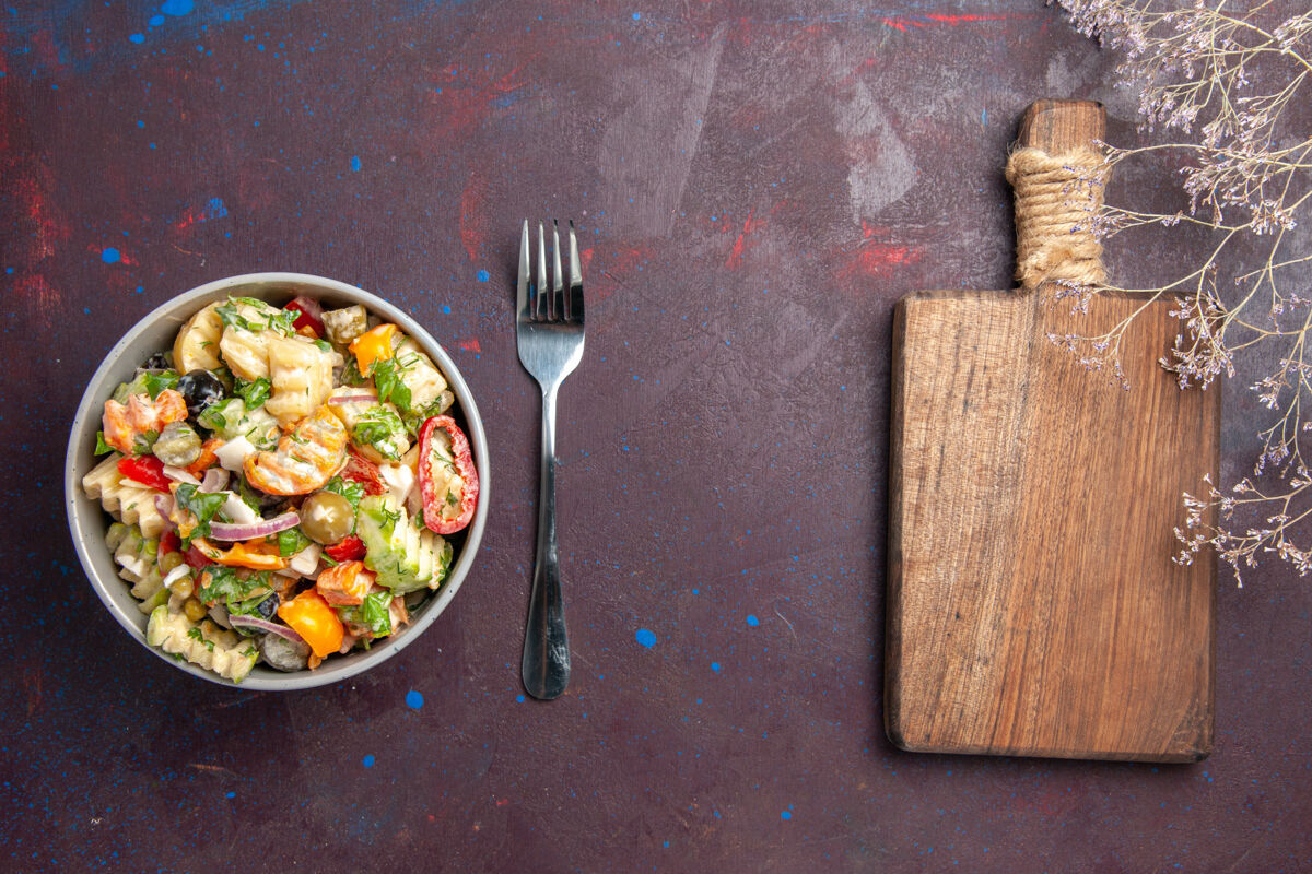 餐厅俯视图美味蔬菜沙拉由西红柿 橄榄和胡椒组成 背景为深色健康沙拉餐观点健康饮食