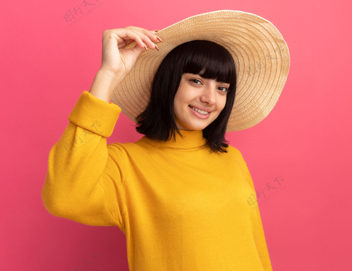 深色微笑的年轻黑发白人女孩戴着沙滩帽看着镜头年轻穿女孩