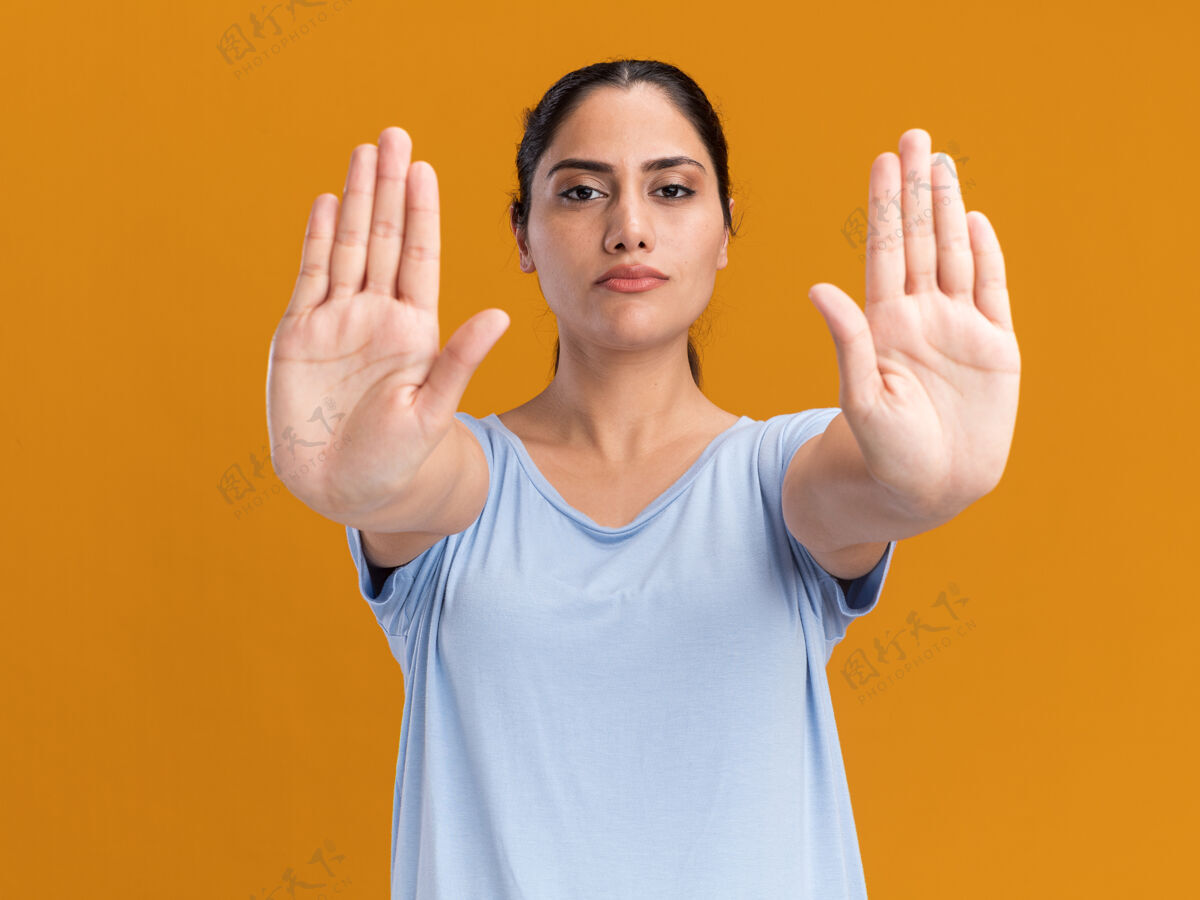 停止自信的年轻黑发白人女孩用双手示意停车标志手两个女孩