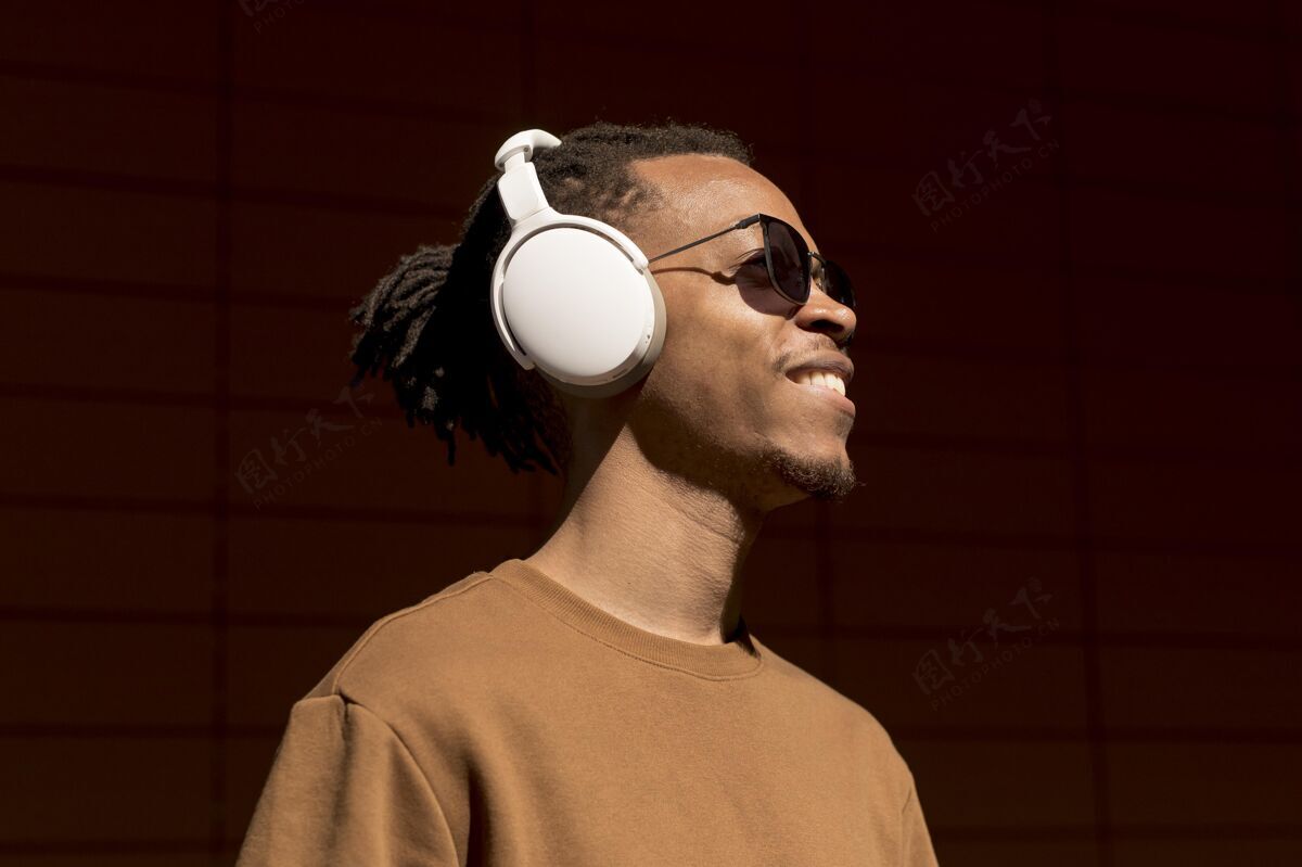 设备戴着耳机的男人近距离看年轻人耳机现代