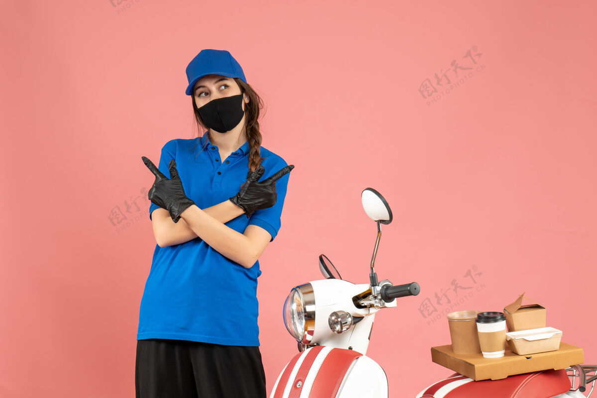 两者俯视图：戴着医用口罩的信使女孩站在摩托车旁边 摩托车上有咖啡蛋糕 粉色背景 两边都是医疗商业侧线