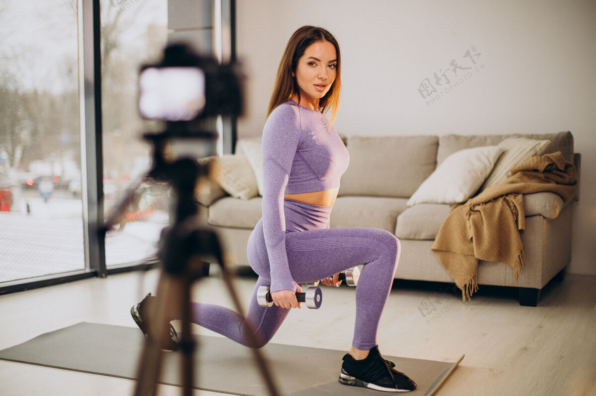 工作女人在家里锻炼和制作视频哑铃地板健身