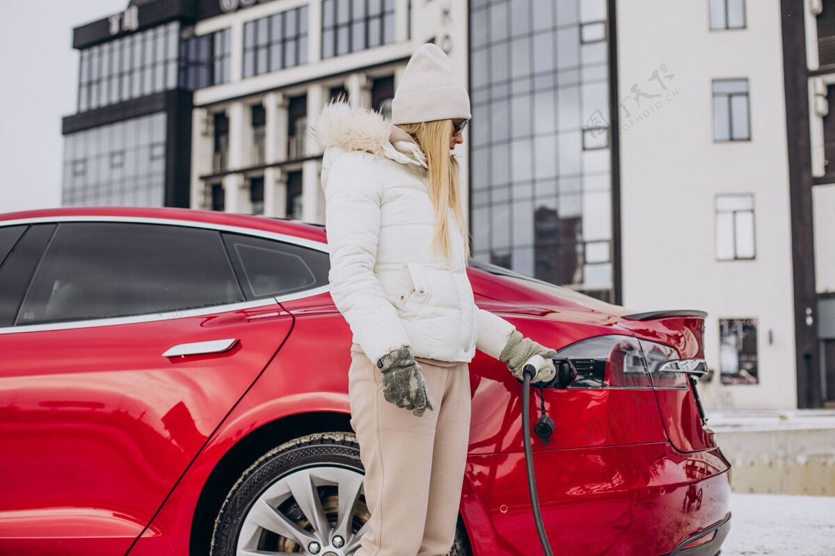 太阳镜女人充电红色电动车 在冬天的时候保险箱车辆驾驶