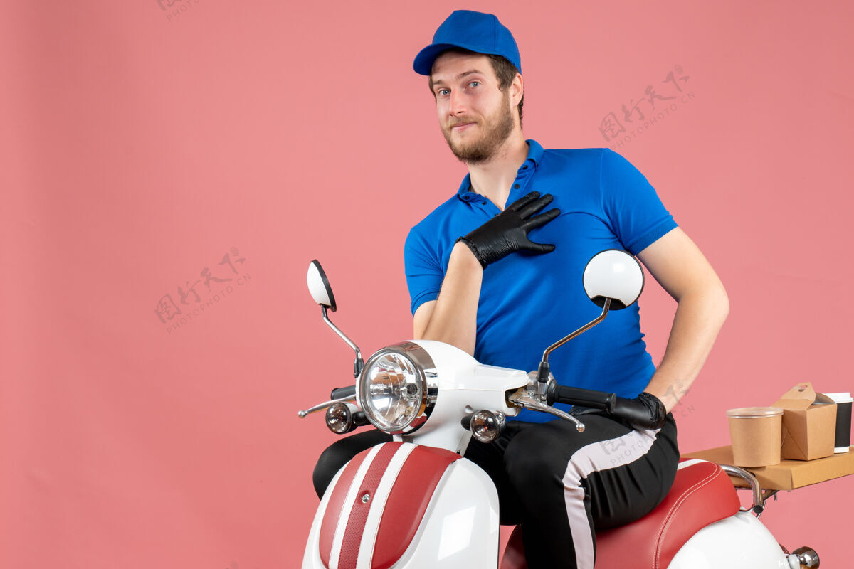 肖像正面图身穿蓝色制服 戴着粉色手套的男快递员工作快餐服务送饭自行车视图送货运动