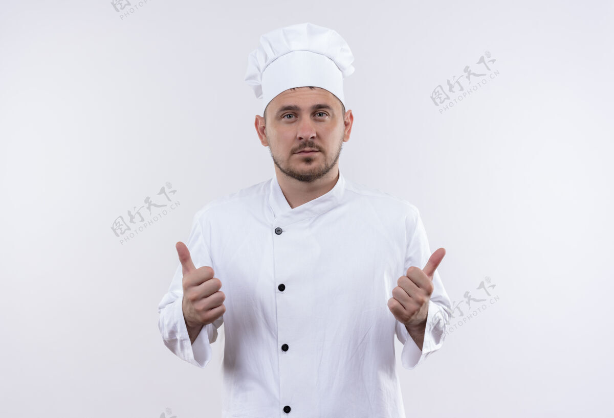 秀自信的年轻帅哥厨师身着厨师制服 竖起大拇指孤零零地站在白墙上自信厨师制服